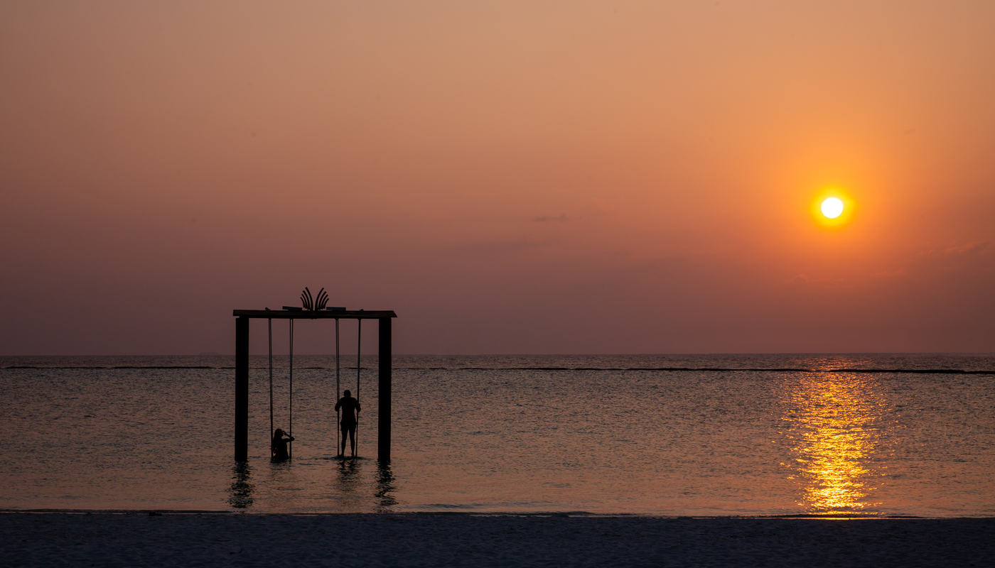 Hotel Adaaran Select Meedhupparu - columpio en el mar al atardecer